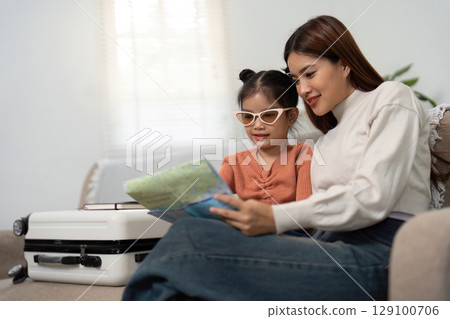 Travel Excitement. Mother and daughter looking at a map together before their trip. Travel Excitement. Mother and daughter looking at a map together before their trip. 129100706