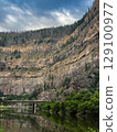 Towering Canyon Cliffs Overlooking a Serene River Valley 129100977