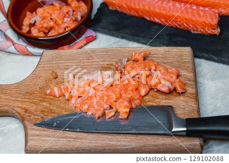 Raw Salmon Being Chopped for Fish Patties 129102088