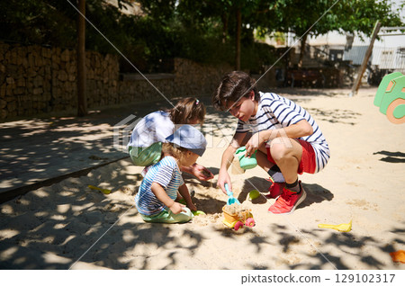 Children Enjoying Playtime Together Outdoors in a Sunny Playground 129102317