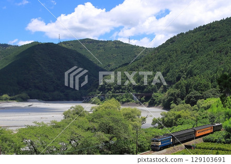 大井川鐵道E31型藍色特快列車在雄偉的大井川背景下悠閒行駛。照片拍攝於2025年7月20日。 129103691