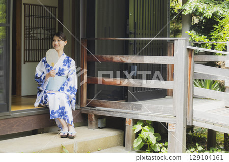 A woman in a yukata sitting on the edge 129104161