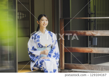 坐在邊緣的yukata的一名婦女 129104167