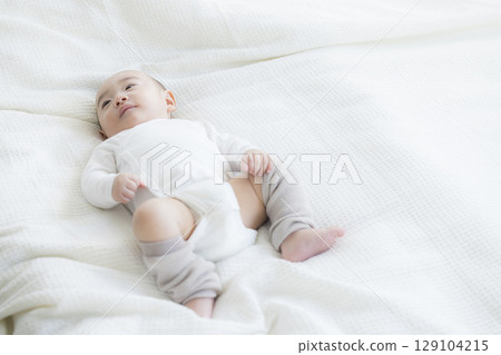 Baby lying on bed Baby lying on bed 129104215