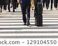 一名商人推著行李箱穿過行人穿越道的腳 129104550