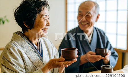 老年協會裡,微笑的老年男女正在舉行茶會 老年協會裡,微笑的老年男女正在舉行茶會 129104600