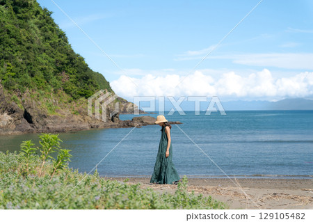 Young woman walking on a sandy beach Young woman walking on a sandy beach 129105482