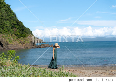 Young woman walking on a sandy beach Young woman walking on a sandy beach 129105485