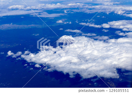 Snow-capped Mount Fuji floating above the clouds as seen from an airplane Snow-capped Mount Fuji floating above the clouds as seen from an airplane 129105551