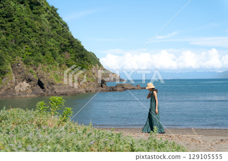 A woman walking along the beach A woman walking along the beach 129105555