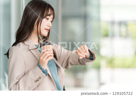 Young Asian businesswoman meeting in front of an office building (wristwatch, schedule, date) 129105722