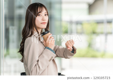 Young Asian businesswoman meeting in front of an office building (wristwatch, schedule, date) 129105723