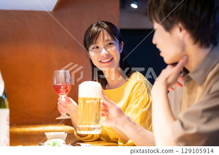 Men and women drinking alcohol at an izakaya 129105914