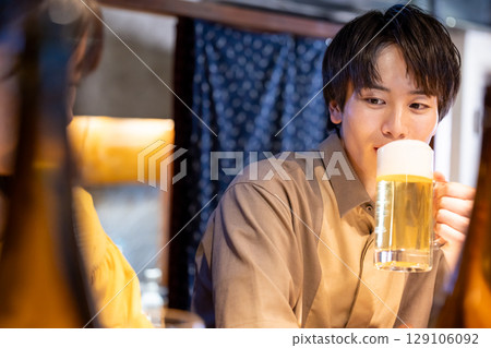A man drinking alcohol at a pub 129106092