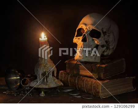 Still Life with burning Candle, Skull and Antique Books. 129106299