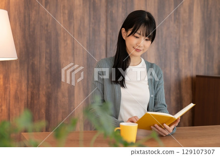 Young woman reading a book 129107307