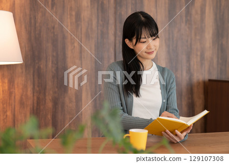 Young woman reading a book 129107308