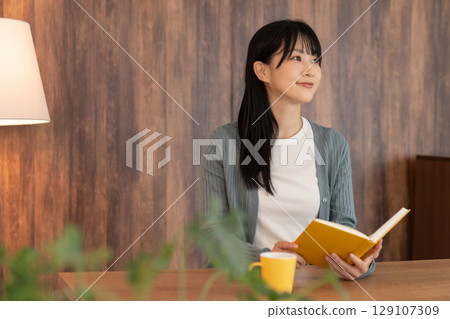 Young woman reading a book 129107309