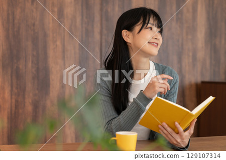 Young woman reading a book 129107314