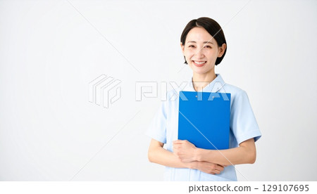 A smiling Japanese female nurse holding a file 129107695