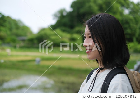 特寫鏡頭：一位微笑女子的側面像，背景是稻田 129107882