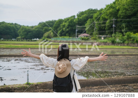 Back view of a woman looking at a rice field 129107888
