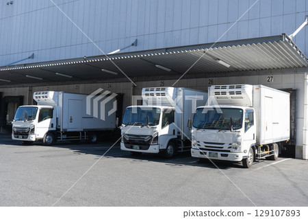 物流倉庫的裝卸區和三輛卡車 物流倉庫的裝卸區和三輛卡車 129107893
