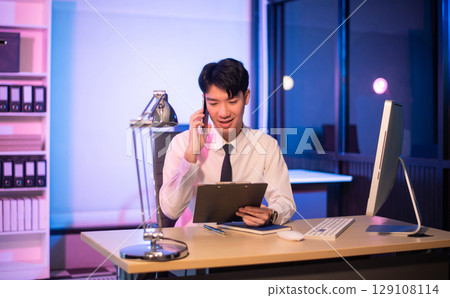 Businessman drinking coffee to get some energy for working overtime sitting at desk using computer and doing overtime Businessman drinking coffee to get some energy for working overtime sitting at desk using computer and doing overtime 129108114