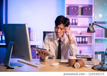 Overworked young Asian businesswoman office worker suffering from neck pain after had a long day at her office desk. Overworked young Asian businesswoman office worker suffering from neck pain after had a long day at her office desk. 129108115
