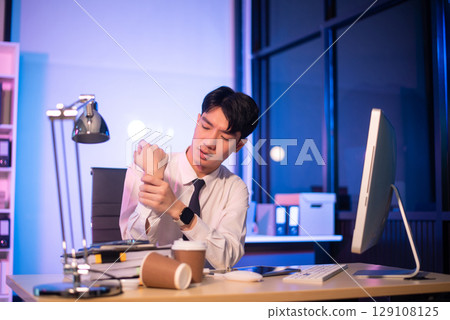 Overworked young Asian businesswoman office worker suffering from neck pain after had a long day at her office desk. Overworked young Asian businesswoman office worker suffering from neck pain after had a long day at her office desk. 129108125