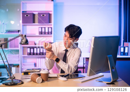 Overworked young Asian businesswoman office worker suffering from neck pain after had a long day at her office desk. Overworked young Asian businesswoman office worker suffering from neck pain after had a long day at her office desk. 129108126