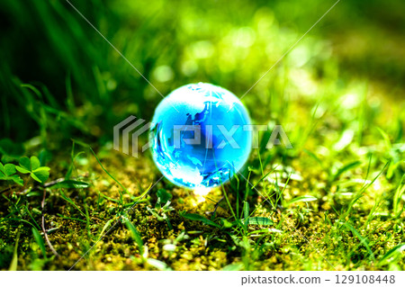 Beautiful globe crystal in the grass. Ecological image. Japan layout top. Blue daylight color. 129108448