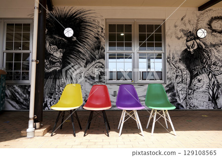 Colorful chairs in a facility with local illustrations painted on the walls Colorful chairs in a facility with local illustrations painted on the walls 129108565