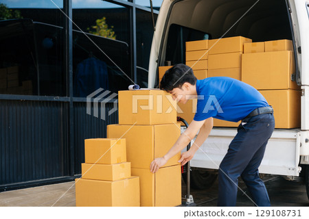 Asian courier delivery man searching the address on digital tablet.  near van outside the warehouse. 129108731