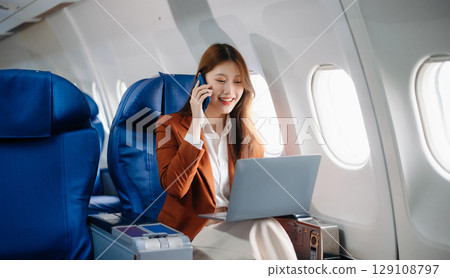 Asian woman sitting in a seat in airplane and looking out the window going on a trip vacation travel concept.Capture the allure 129108797