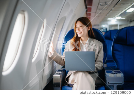 Asian Woman Working on Tablet During in first class, multitasking with Flight Travel in style, work Asian Woman Working on Tablet During in first class, multitasking with Flight Travel in style, work 129109000