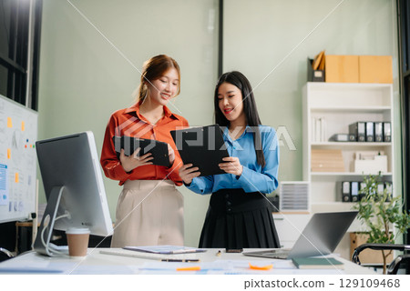 Two Asian businesswoman and man discuss investment project working and planning strategy with tablet laptop computer Two Asian businesswoman and man discuss investment project working and planning strategy with tablet laptop computer 129109468
