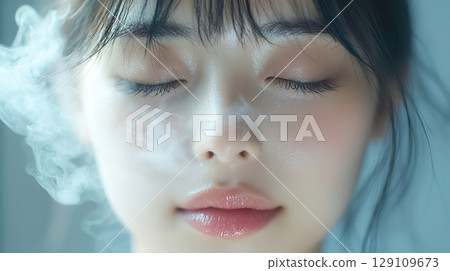 A young woman applying steam to her face (steam beauty salon) 129109673