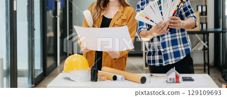 Engineer teams meeting working together wear worker helmets hardhat with on architectural project site and making model house. Engineer teams meeting working together wear worker helmets hardhat with on architectural project site and making model house. 129109693