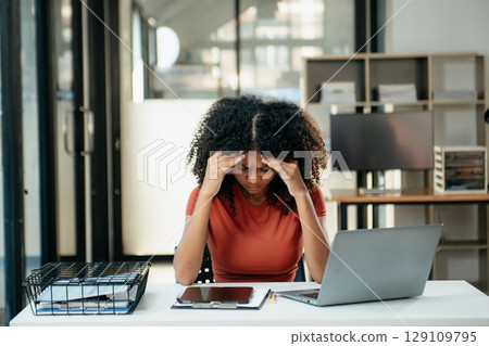 Business woman is stressed, bored, and overthinking from working on a tablet at office. Business woman is stressed, bored, and overthinking from working on a tablet at office. 129109795