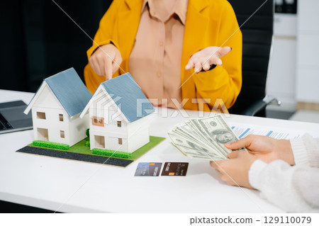 balancing the property sector The real estate agent is explaining the house style to see the house design and the purchase agreement. 129110079