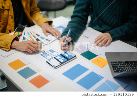 UX developer and ui designer brainstorming about mobile app interface wireframe design with customer breif and color code 129110159