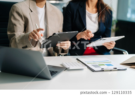 Businessman and team analyzing financial statement Finance task. with smart phone and laptop and  tablet. 129110335