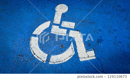 blue handicapped parking symbol painted on an asphalt surface, representing accessibility and inclusivity for people with disabilities. Rustic disabled parking sign blue handicapped parking symbol painted on an asphalt surface, representing accessibility and inclusivity for people with disabilities. Rustic disabled parking sign 129110673