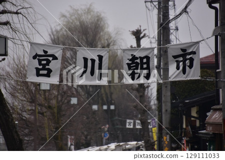 日本岐阜縣高山市：高山春節期間，宮川早市的入口和招牌，一排排含苞待放的櫻花樹和多雲的天空 129111033