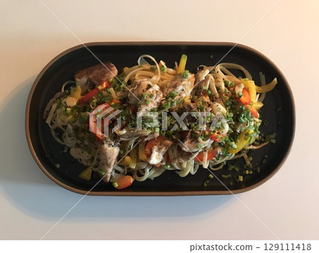 A plate of spaghetti pasta, perfectly cooked and topped with rich marinara sauce and fresh herbs. Ideal for food photography and menus, capturing the heart of Italian cuisine in a delicious way. 129111418