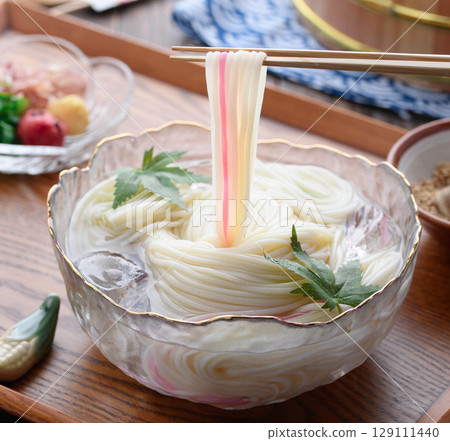 A set of hiyamugi and condiments floating in ice water, creating a refreshing Japanese summer dining scene A set of hiyamugi and condiments floating in ice water, creating a refreshing Japanese summer dining scene 129111440