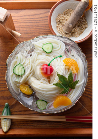 A set of hiyamugi and condiments floating in ice water, creating a refreshing Japanese summer dining scene 129111451