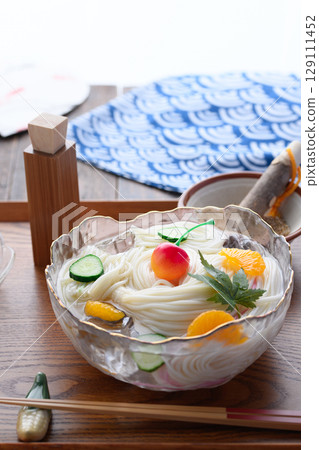 A set of hiyamugi and condiments floating in ice water, creating a refreshing Japanese summer dining scene 129111452