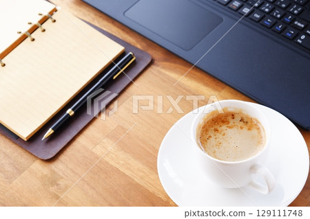 影像顯示，一名工作人員在辦公桌前工作，打開環形系統整理器，喝著咖啡（拿鐵咖啡），在電腦前進行案頭工作 129111748